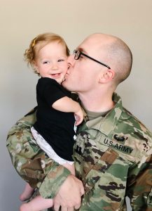 Military Dad kissing his baby daughter