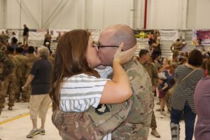 Military couple kissing at the deployment homecoming