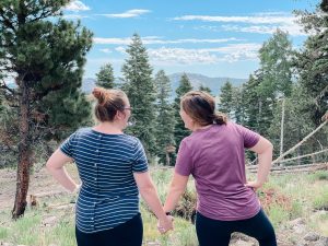 Military Spouses enjoying view after hiking a mountain together